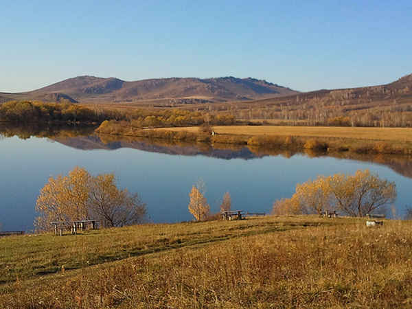 Пруд у подножья горы осенью
